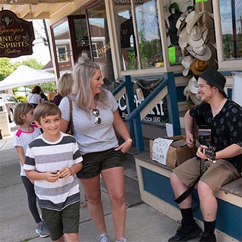 shoppers in Branchville passing by a guitar player outside a shop